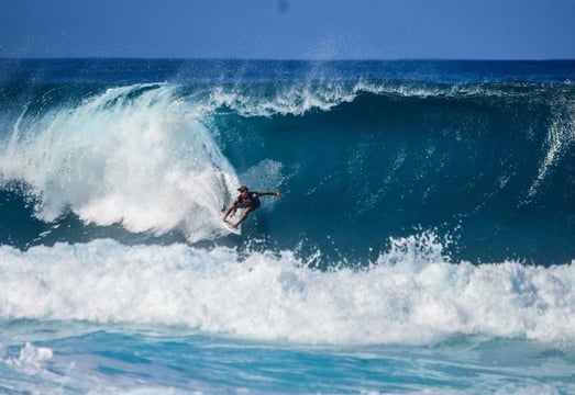 Surfer riding a large breaking wave